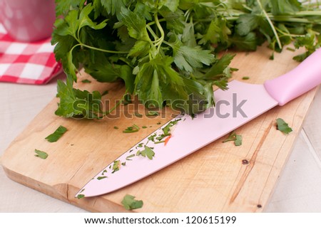 Cutting board with knife and parsley chopping horizontal