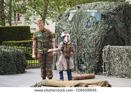 BRUSSELS, BELGIUM - JULY, 21: Unidentified soldier shows to a minor how to use vision equipment during National Day of Belgium celebrations on July 21, 2012 in Brussels.