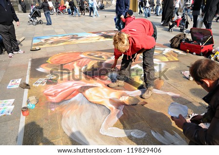 COLOGNE, GERMANY-APRIL 10: Unidentified street artists produce a beautiful painting on pavement on front of cathedral on April 10, 2010 in Cologne.