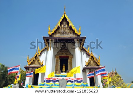 Beautiful Buddhist temple in Phuket village with yellow flags with religious symbols, Thailand