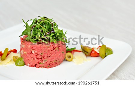 Steak tartar prepared in Italian manner with balsamic vinegar from Modena and green olives