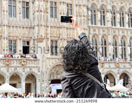 BRUSSELS, BELGIUM-AUGUST 15, 2014: Tourist taking pictures on Grand Place. This square in one of the mostly photographed sites in the world