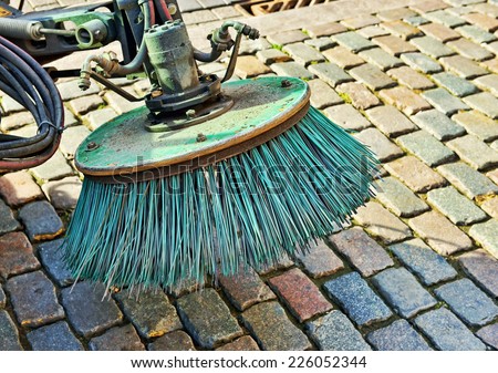 Brush of old street cleaning machine on street stones
