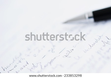 Shallow DOF photo of white paper with custom text and blurred ball pen