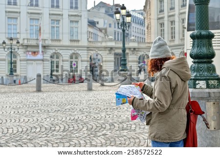 BRUSSELS, BELGIUM-MARCH 06, 2015: Young tourist reads map of Brussels in historical center of city