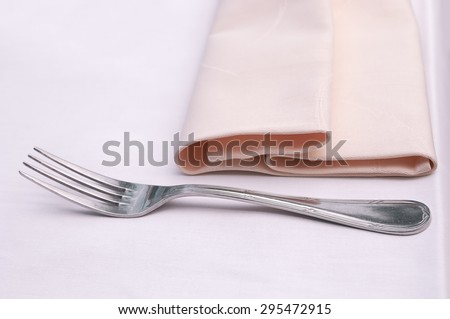 Fork and a napkin on a light table. Vintage effect and tone applied
