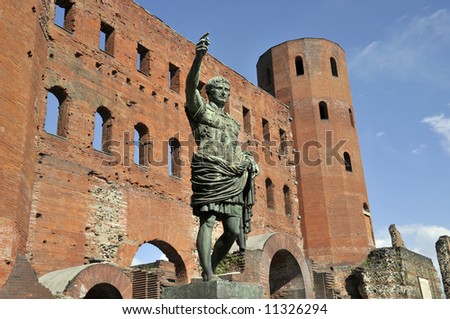 Ruins of gates of roman times with statue on front of it in Turin, Italy - porta palatina