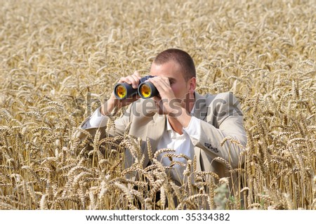 agent of secret service watching through binoculars in the field