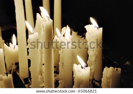 White candles in catholic church on dark background