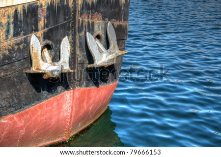 Nose of rusted abandoned boat in calm water