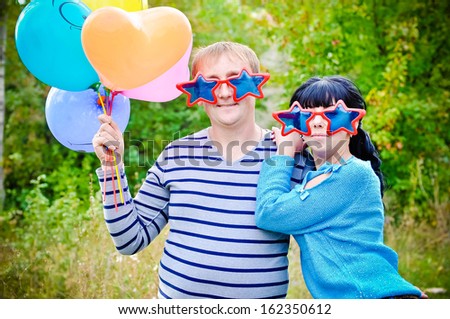 Couple in funny glasses with balloons outdoors