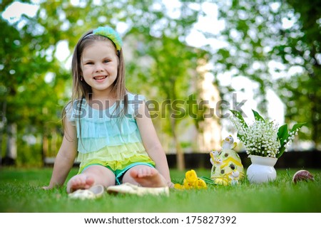 Little girl having rest on the meadow on Easter day