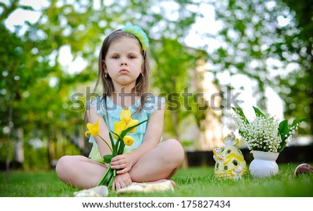Little girl having rest on the meadow on Easter day