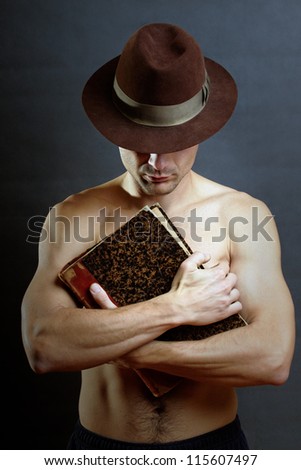 naked muscle man holding old secret book