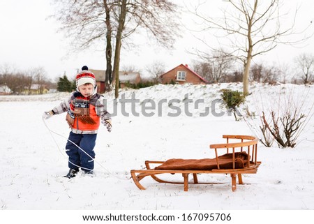 child boy on a sled having fun in the snow
