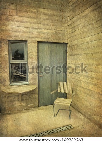 A chair standing in the corner to an entrance, in grungy style.