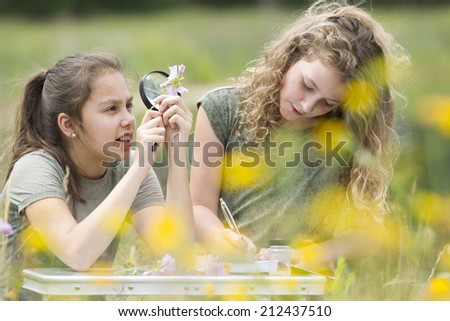 Pretty young girls having outdoor science lesson  exploring nature