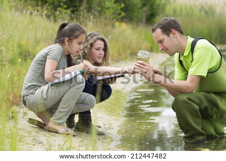 Pretty young girls having outdoor science lesson  exploring nature