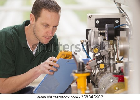 Senior technician repairing agriculture machinery in a greenhouse