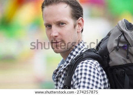 Side view of confident mid adult man carrying backpack outdoors