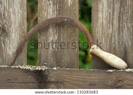 Old wooden hammer on the background of the village fence