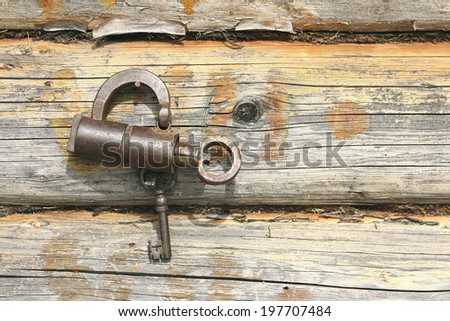 Vintage padlock with keys on a wooden wall background
