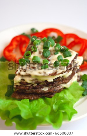 Liver cake flavored with garlic sauce, green salad and red pepper