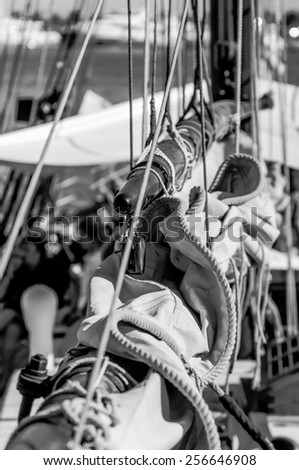 Close up view of the deck of an old sailing yacht with several chords and other equipments. Black and white conversion, vertical frame.
