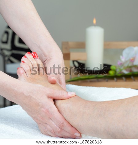 Applying foot massage in body care center