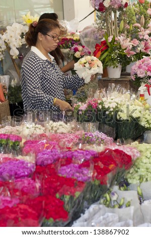 BANGKOK, THAILAND : OCT 12: Woman making flower bouquet on Bangkok\'s flower market on October 12th 2012. Pak Khlong Talad is Bangkok\'s biggest flower market.