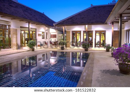 Beautiful, luxury, Balinese style  holiday villa in Phuket, Thailand lit up and reflected in the swimming pool taken early evening during the blue hour.. Image by Kevin Hellon.