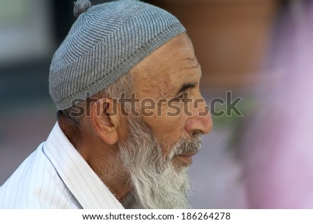 Alanya, Turkey-September 20th 2011: Man wearing a traditional Turkish skull cap. The cap is made of wool or cotton and has a pom pom on top.