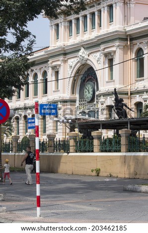 HO CHI MINH CITY,VIETNAM-NOV 4TH 2013: People walking past the Central Post Office. The architecture is neo classical and was desingned by Gustave Eiffel.