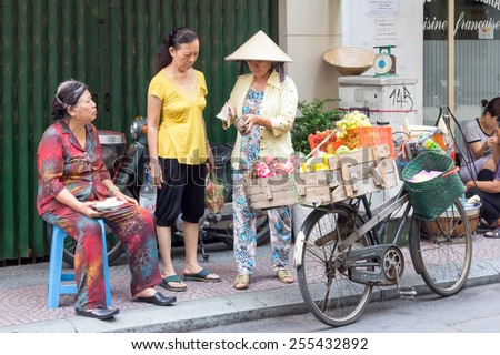 Ho Chi Minh City-Oct 31st2013: Vendor on bicycle selling to customers. Street vendors can be found all over the city.