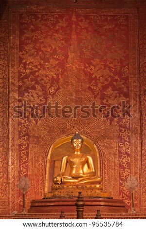 Golden Buddha statue (Phra Sihing Buddha) and art background in Wat Phra Singha, Chiang Mai Province, Thailand.