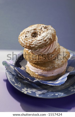 blue still life: short pastry with pink cream and icing sugar on the blue plate