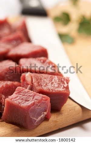 shards of meat with kitchen knife on the wood board