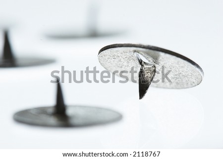 macro picture of three drawing - pin over light background
