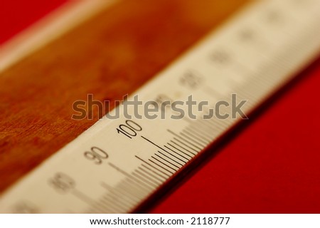 macro picture of wooden ruler on the red background, very shallow DoF.