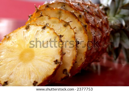 fruit still life: sliced ripe pineapple over red background