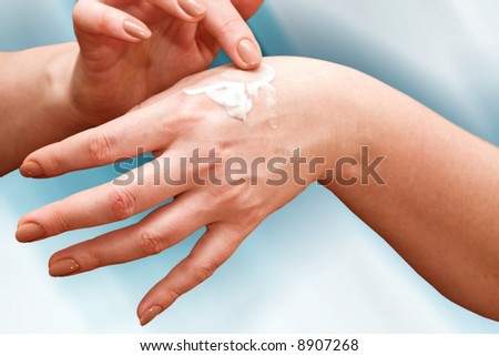 female applying cream to her hands, body care
