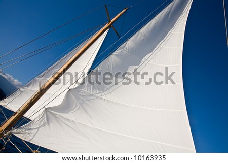 Yacht sail and blue cloudless aky above