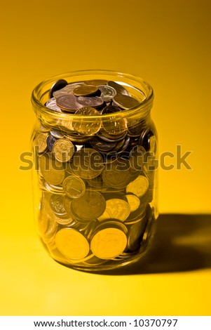 business metaphor: glassy jar with Russian coins over yellow