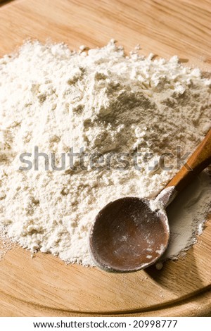 wheat flour on the wooden board with spoon