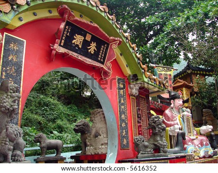Colorful oriental temple in Hong Kong, with round shaped door & lion statues
