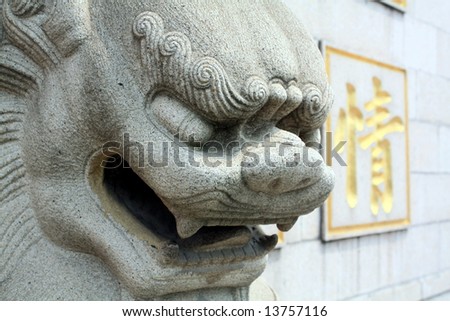 Chinese Lion statue against Chinese calligraphy: word for \