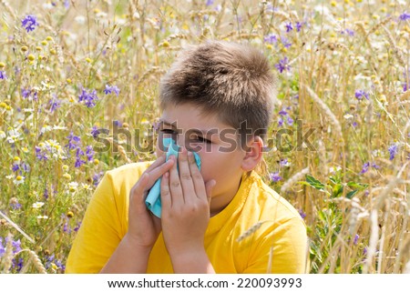 Boy with allergic rhinitis in the meadow