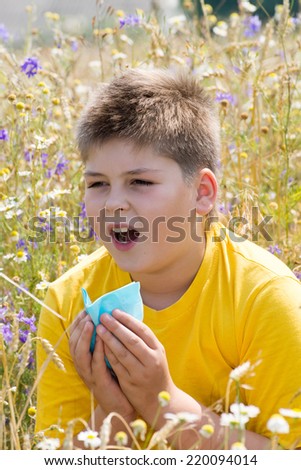 Boy with allergic rhinitis in the meadow