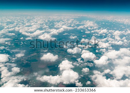 View of the land, fields, and clouds from above