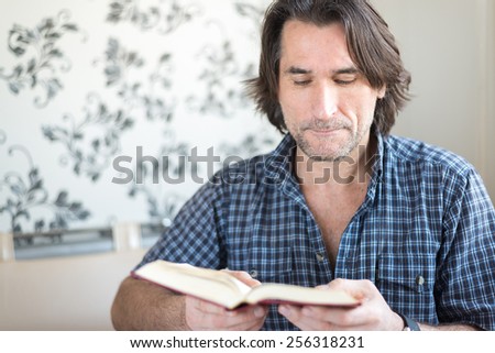 A man reads a book at the table